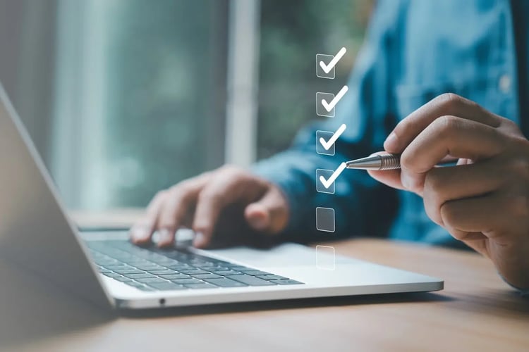 Digitale Checkliste wird auf Laptop abgehakt, Symbol für Aufgabenmanagement und Berechtigungen bei der ISO-Gruppe im IT-Kontext.